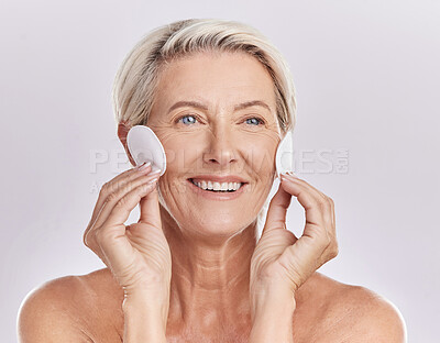 Buy stock photo Grooming, skincare and hygiene by a mature woman apply cleanser or toner to her face with cotton pads. Senior female remove makeup and enjoying a routine pamper facial treatment against copy space