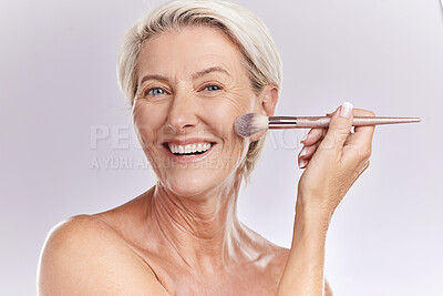 Buy stock photo Beauty, makeup and cosmetics of senior woman with a make up brush applying foundation, concealer or cosmetic product with a smile portrait. Happy blonde lady showing skincare for reducing wrinkles