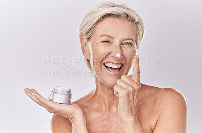 Buy stock photo Portrait, cream and beauty with senior woman, happy with skincare and dermatology on white background. Sunscreen, moisturizer and face care, female model apply lotion with glass container and skin