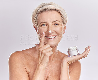 Buy stock photo Beauty, cream and senior woman with skincare, dermatology and happy in portrait on white background. Sunscreen, moisturizer and face care, female model apply lotion with glass container and antiaging