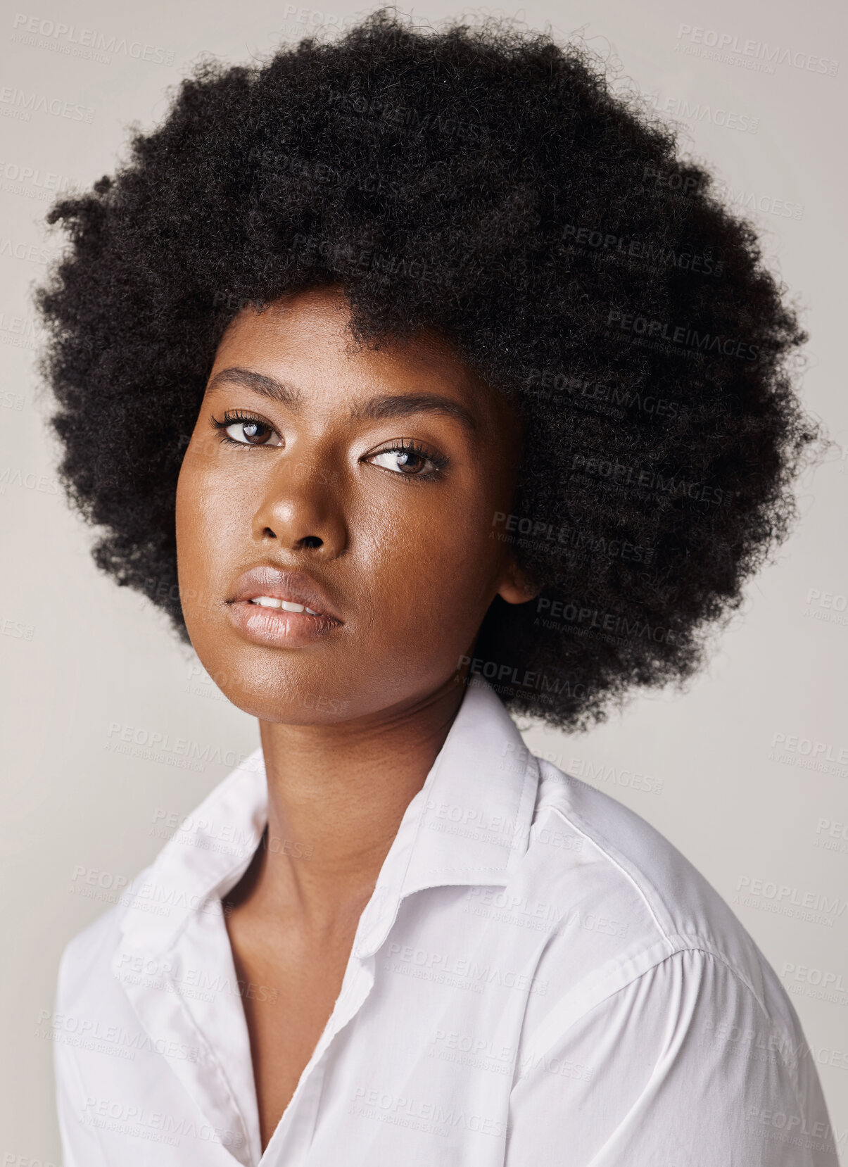 Buy stock photo Studio portrait of a young stunning African American woman with a beautiful afro. Confident black female model showing her smooth complexion and natural beauty while posing against a grey background