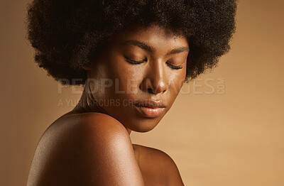 Buy stock photo Beautiful african american woman with afro hair and glowing radiant skin posing against a brown studio background. Young woman wearing natural make-up and looking flawless and confident