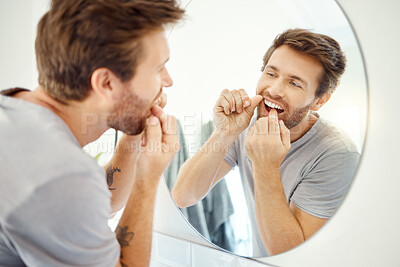 Buy stock photo Dental floss, morning and mirror with man in bathroom for self care, oral hygiene and teeth. Cleaning, smile and health with face of male person at home for beauty, wellness and reflection