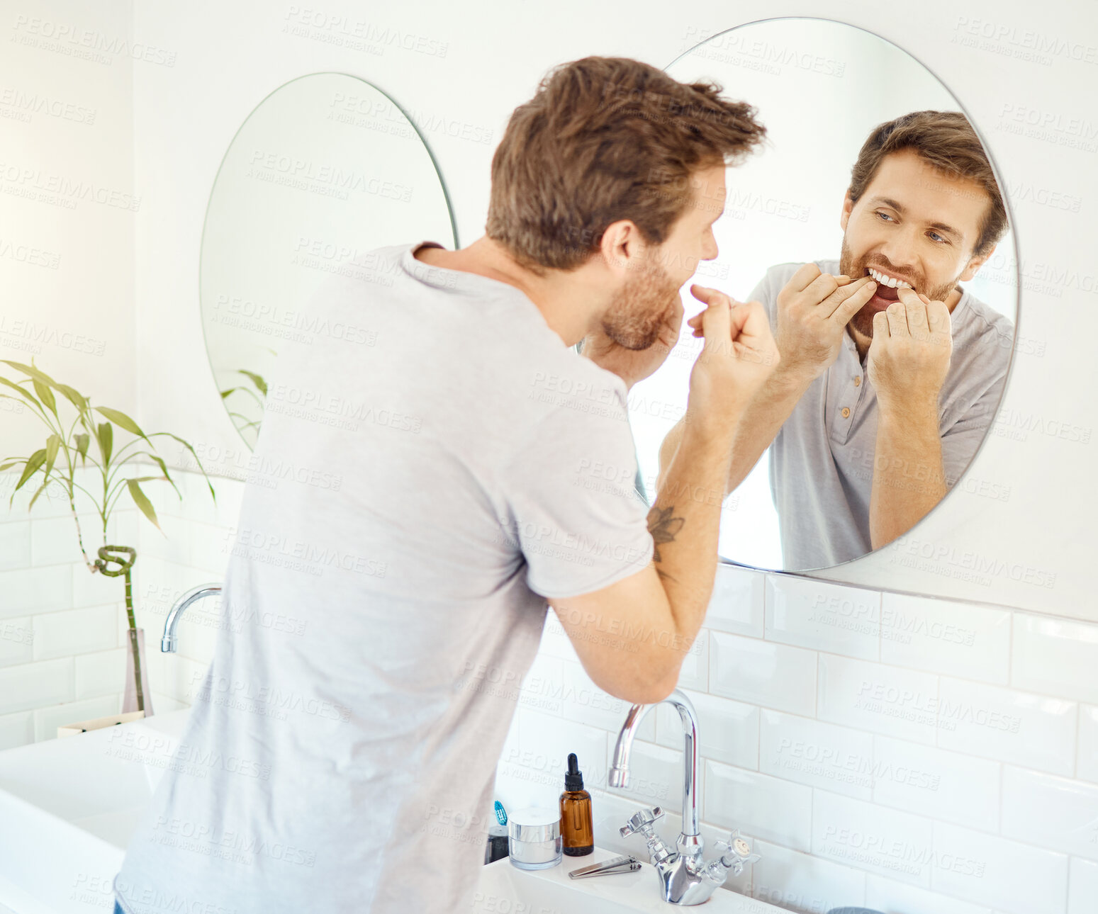 Buy stock photo Dental floss, morning routine and mirror with man in bathroom for self care, oral hygiene and teeth. Cleaning, smile and health with face of male person at home for beauty, wellness and reflection