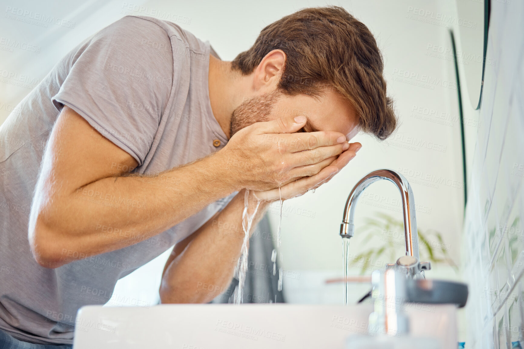 Buy stock photo Man, washing and face with water for cleaning at tap in bathroom, morning skincare routine and grooming at home. Young guy, facial and wet splash at faucet, basin and dermatology for personal hygiene