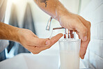 One unknown man washing his hands in a bathroom at home. Unrecognizable male using soap to kill bacteria and prevent the spread of viruses in a basin at home in his apartment