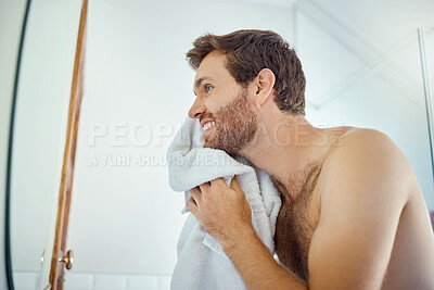 Buy stock photo Man, cleaning face and towel in mirror with smile, self care and hygiene to start morning in home bathroom. Young guy, person and cloth for beauty, facial cosmetics and wellness for beard in house