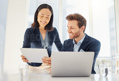 Two happy young diverse colleagues working together on a digital tablet in an office. Confident asian businesswoman and smiling caucasian businessman brainstorming corporate plans and ideas on device. Secretary assisting boss at work