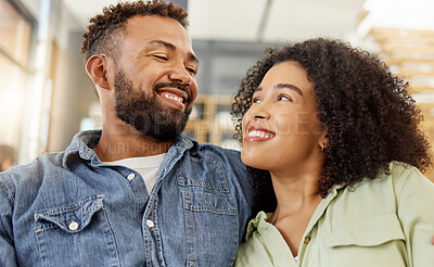 Buy stock photo Young mixed race couple smiling while staring into each other’s eyes on the couch at home. Happy hispanic boyfriend and girlfriend sitting on the sofa together