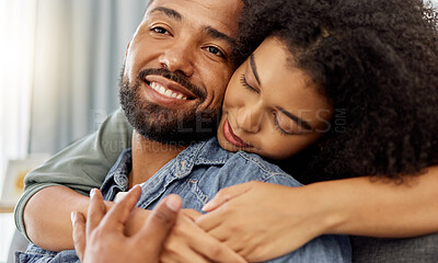 Buy stock photo Happy mixed race couple embracing while relaxing at home. Hispanic boyfriend and girlfriend smiling while spending time together in the lounge at home