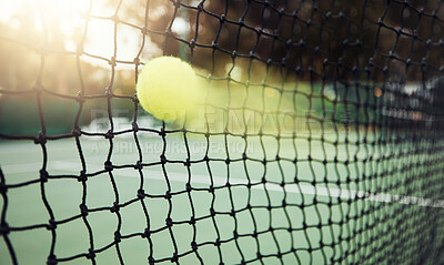 Buy stock photo Closeup of one yellow tennis ball with motion blur hitting a net during a game on a court. Fast ball moving with speed during a competitive sports match in a sports club. Losing by touching the net