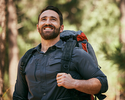 Buy stock photo One happy mature caucasian man carrying a backpack and hiking alone in the woods during the day. Smiling fit and active man enjoying nature while exercising and exploring. Staying active on adventures