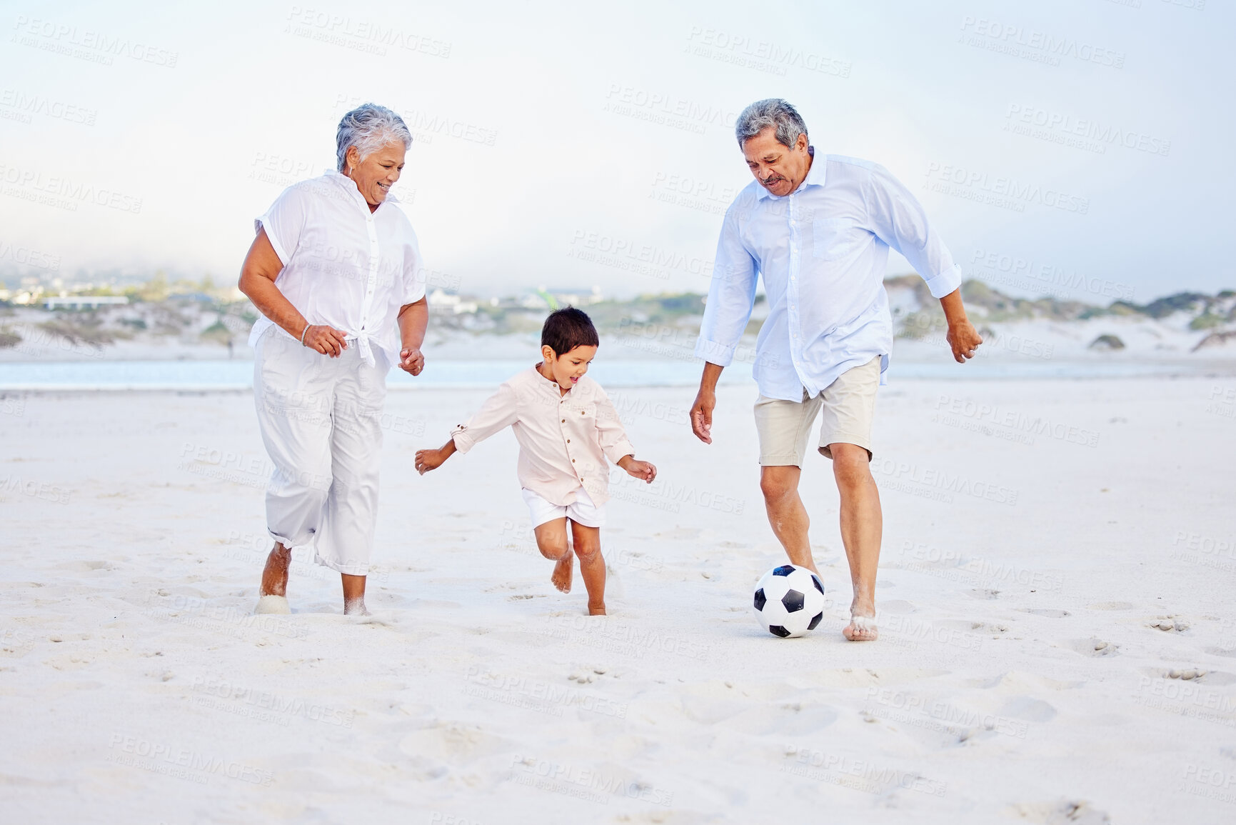 Buy stock photo Beach, football and grandparents playing with kid on vacation or holiday happy for sand soccer or sports. Travel, summer and elderly man and woman kicking a ball with child at the ocean together