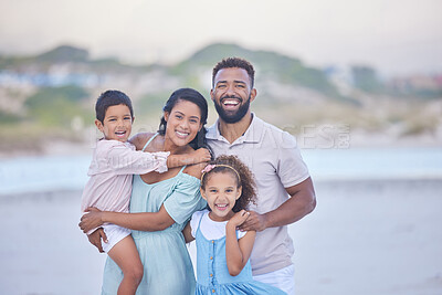 Buy stock photo Portrait of a happy mixed race family standing together on the beach. Loving parents spending time with their two children during family vacation by the beach