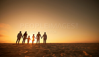 Full length of multi generation family silhouetted on the beach. Carefree family with two children, two parents and grandparents holding hands and watching the sunset at the beach