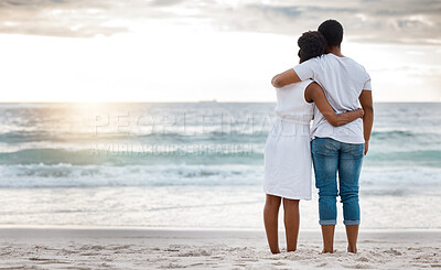 Buy stock photo African American couple spending a day at the sea together. Caring boyfriend and girlfriend watching the view on the beach. Loving husband and wife smiling while standing on the beach