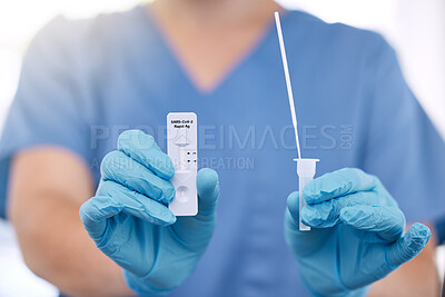 Buy stock photo Unrecognizable doctor wearing gloves holding a covid test and a cotton swab while working alone at a hospital. One unrecognizable nurse working with a cotton swab and covid test at a clinic 