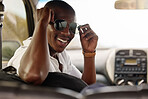One young african american man wearing stylish sunglasses while driving in a car during a road trip. Happy black male enjoying summer and the weekend by traveling, touring and exploring sightseeing 