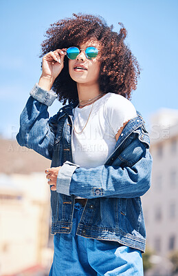 Buy stock photo Woman, fashion and sunglasses outdoor in city for streetwear, summer and travel on a street. African person with natural hair or afro and urban background, glasses and jeans or clothes for freedom