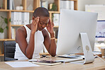 One young African american businesswoman suffering from a headache while feeling exhausted and depressed at an office job while sitting in front of her computer. Stress and anxiety leads to a breakdown at work which makes the mind tired and overworked