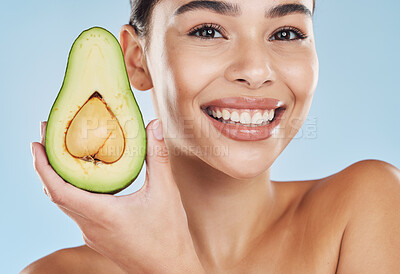 Buy stock photo Avocado skincare, woman beauty and cosmetic wellness for healthy diet, happy results and clean glowing skin on blue background. Portrait, smile and young model face, grooming and fresh fruit bodycare