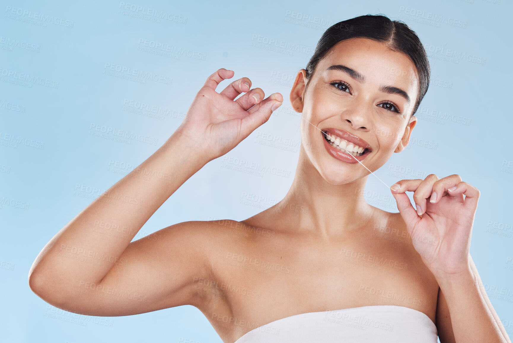 Buy stock photo Oral, dental and flossing woman cleaning teeth in a studio blue background mockup. Young model with white or perfect smile, clean mouth or gums portrait for hygiene, healthcare and dentistry mock up