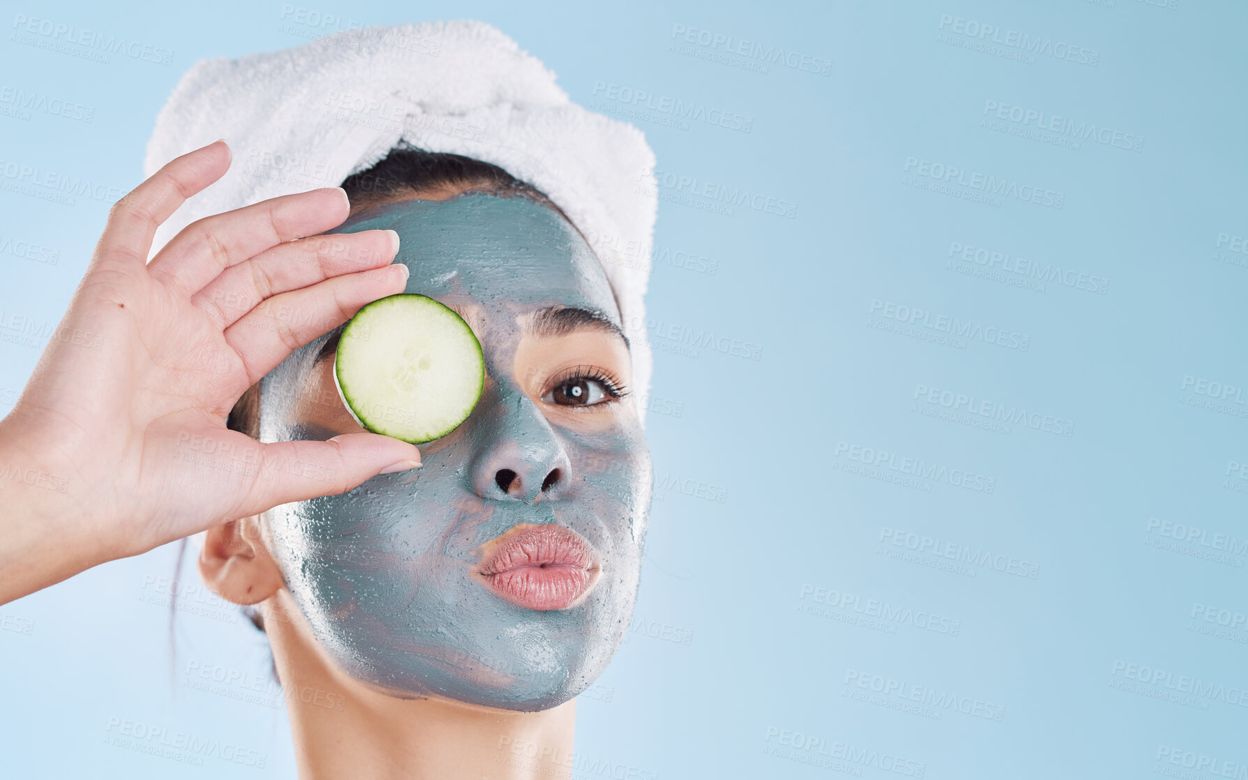 Buy stock photo Beauty, cosmetics and skincare by woman grooming with a face treatment and cucumber against studio background. Young female enjoy self care and organic products during routine pamper wellness session