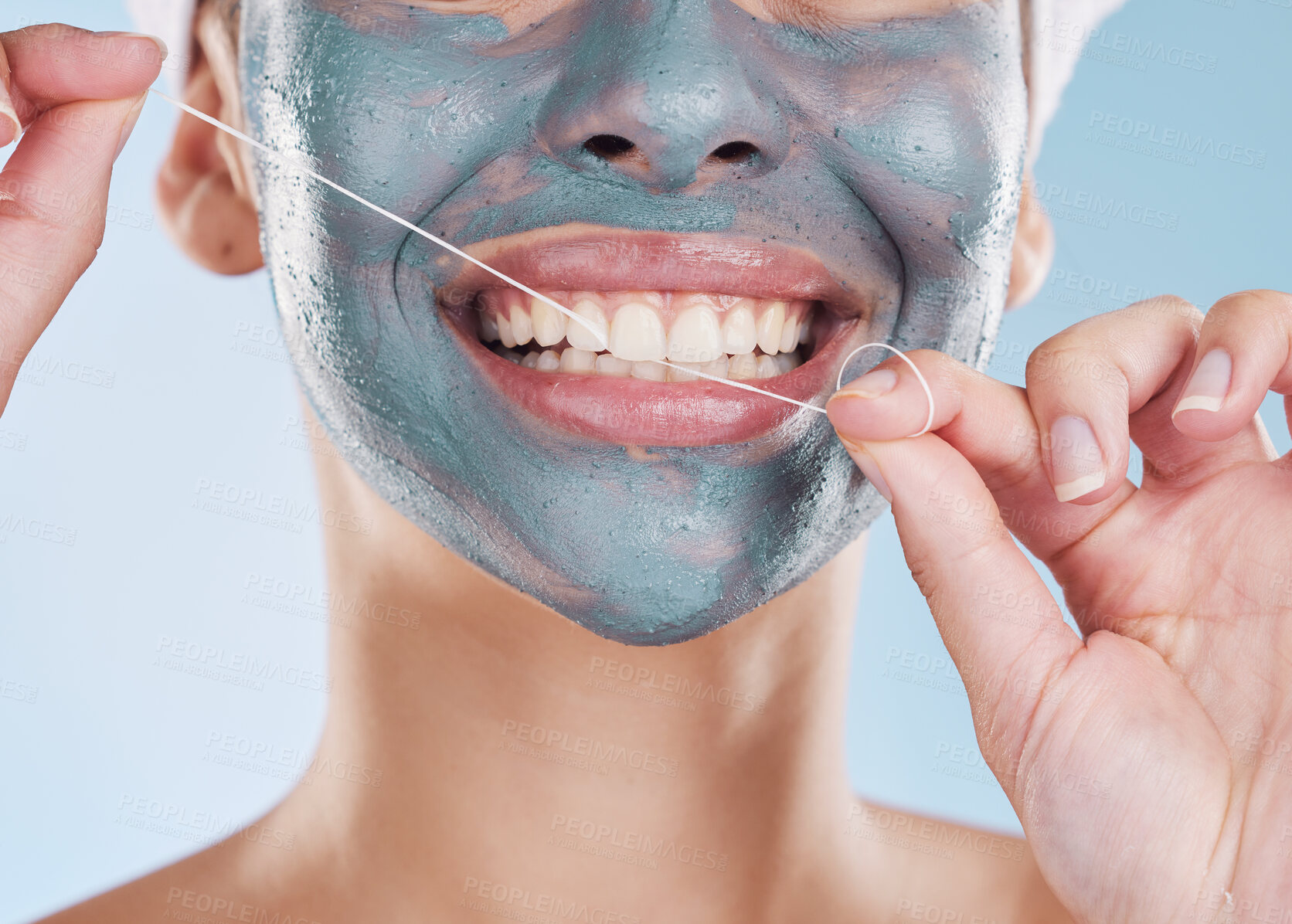 Buy stock photo Dental, face mask and woman flossing her teeth for healthy and strong teeth in a studio portrait with a blue background. Girl cleaning her mouth, face and skin with beauty self care and oral hygiene