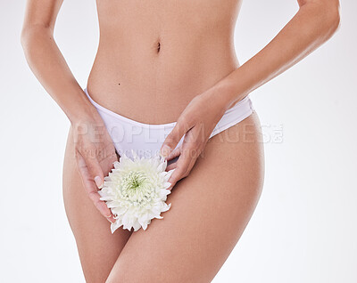 Closeup of unrecognizable mixed race model posing with a flower against white copyspace background. Unknown Hispanic woman promoting natural products for feminine hygiene and UTI remedies in a studio