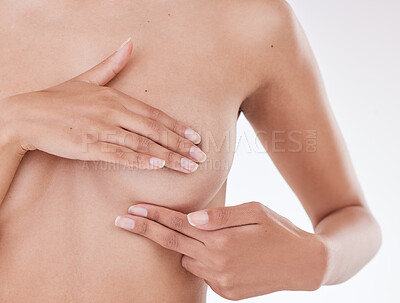 Closeup of unrecognizable woman posing against a white studio background while creating awareness for breast cancer . One female only feeling her boobs for a lump while doing a self exam in a studio