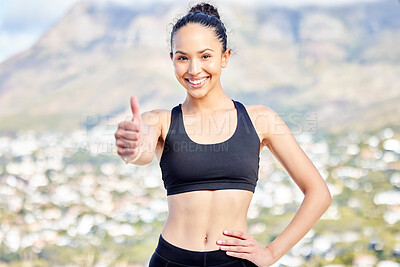 Portrait of one confident young mixed race woman gesturing thumbs up while exercising outdoors. Happy female athlete looking motivated and ready for a good training workout or run. Endorsing a healthy active lifestyle