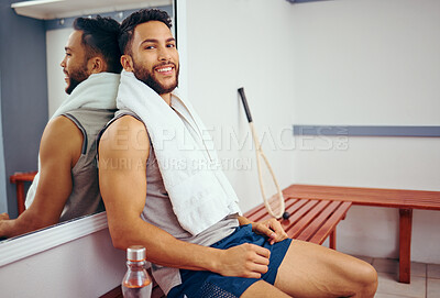 Buy stock photo Young athlete sitting in a gym locker room. Mixed race athlete taking a break from his workout. Portrait of smiling fit man relaxing in his gym. Hispanic player resting after a match