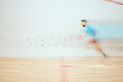 Buy stock photo Young athletic squash player running while playing court game with copyspace and motion blur. Fit mixed race athlete moving with speed during training practice in sports centre. Sporty hispanic man