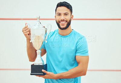 Buy stock photo Portrait of squash player smiling and holding trophy after playing and winning court game with copyspace. Fit active hispanic athlete standing alone and feeling successful after championship challenge
