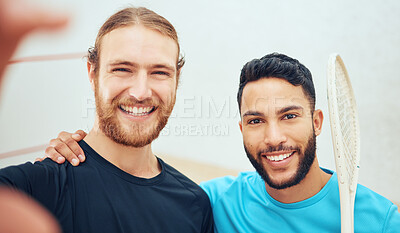 Buy stock photo Portrait of two young athletic squash players taking selfie after playing court game. Smiling fit active Caucasian and mixed race athlete standing close together, posing for picture for social media