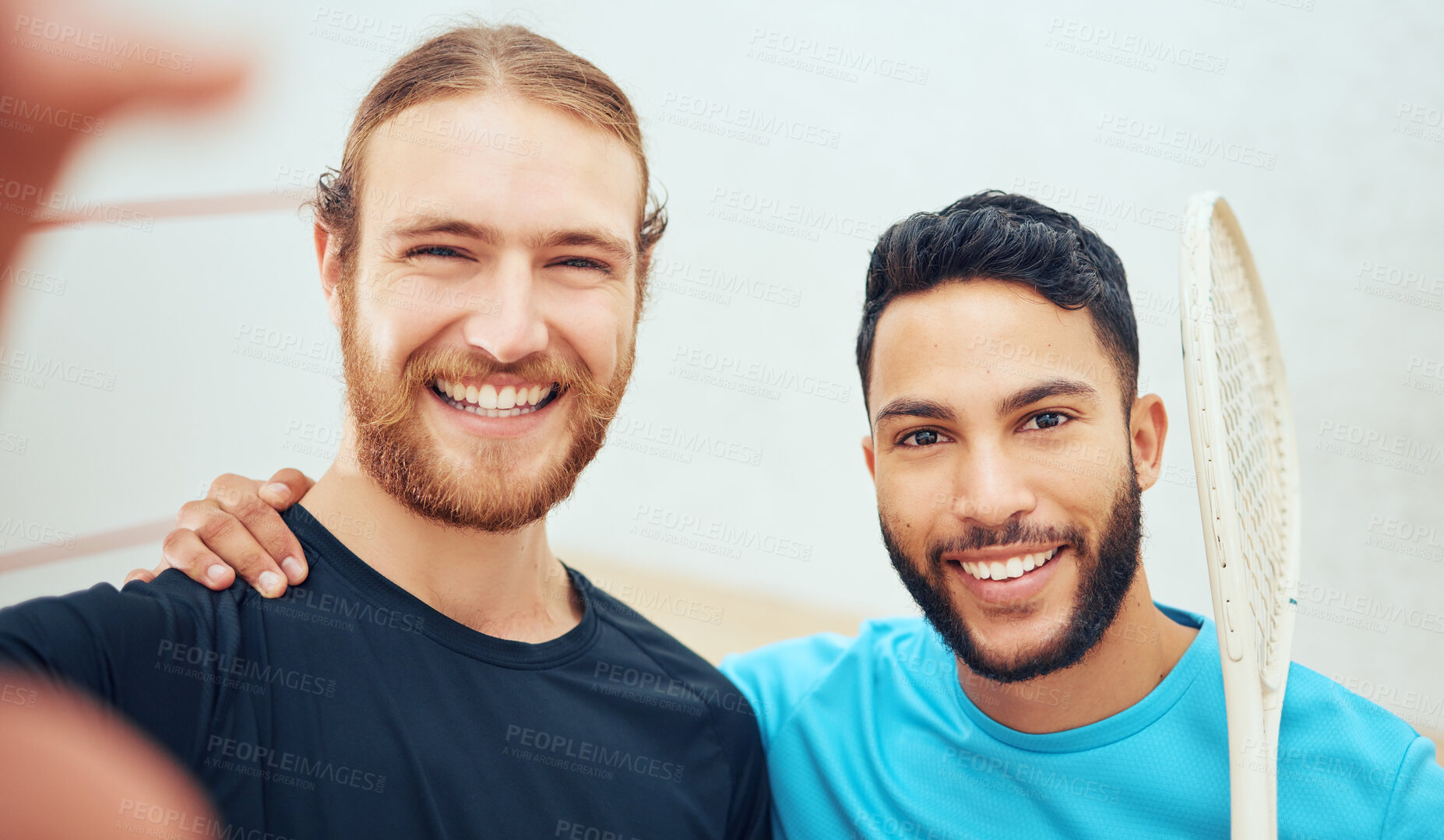 Buy stock photo Portrait of two young athletic squash players taking selfie after playing court game. Smiling fit active Caucasian and mixed race athlete standing close together, posing for picture for social media