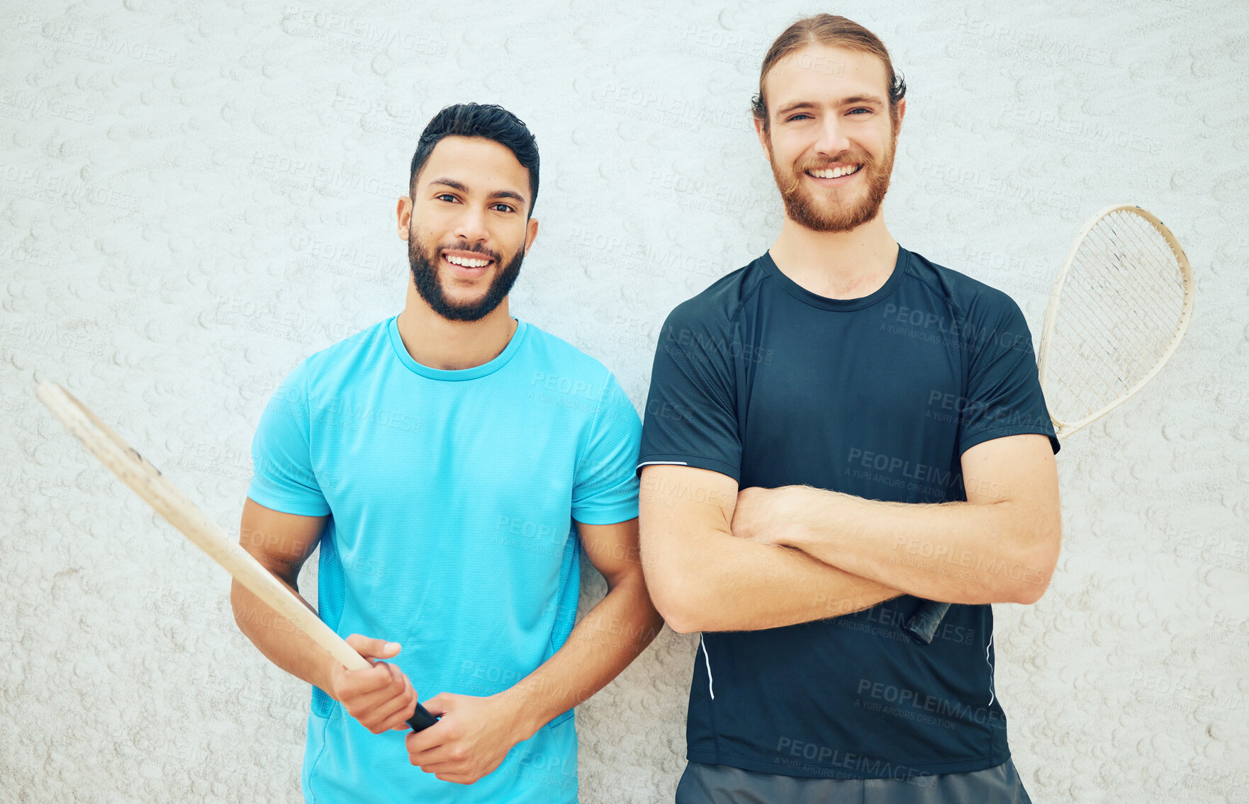 Buy stock photo Portrait of two squash players smiling and holding rackets before playing court game with copyspace. Fit active mixed race and caucasian athletes together before training practice in sports centre