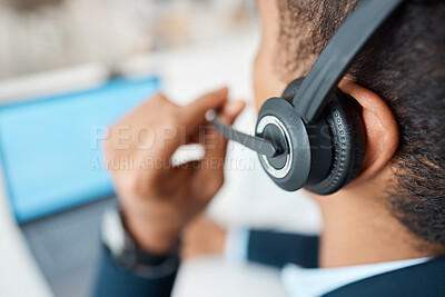 Mixed race male call center agent answering calls while wearing a headset alone at work. One hispanic businessman talking on a call at a desk in an office