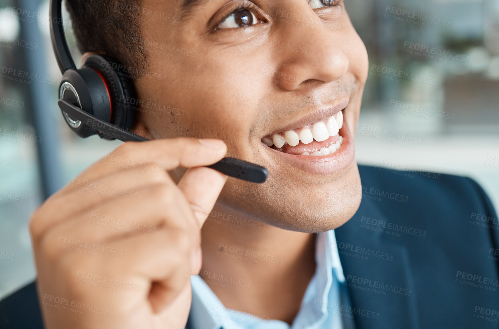 Buy stock photo Closeup of a young happy mixed race male call center agent answering calls while wearing a headset and thinking alone at work. Face of a hispanic male assistant smiling while talking on a call at a desk in an office