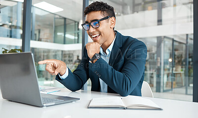 Buy stock photo Happy mixed race businessman pointing a finger while working on a laptop alone at work. Hispanic male businessperson smiling and reading an email on a laptop while working in an office