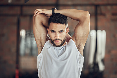 Buy stock photo Portrait of young athlete stretching his arms in the gym. Young man warming up before a workout. Fit bodybuilder stretching his shoulder in the gym. Always prepare before a workout