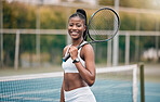 Young girl holding a tennis racket on the court. African american tennis player ready for her match. Portrait of a happy tennis player on the court. Confident player standing on the court