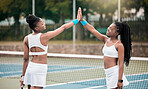 Happy friends high five on the tennis court. Two professional tennis players motivate each other after a match. African american girls bonding, celebrate and support each other