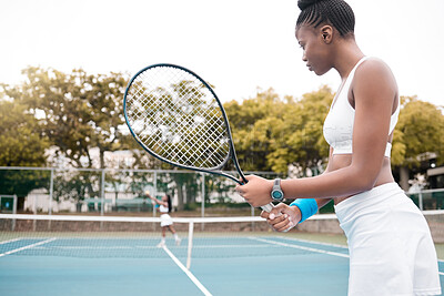 Woman waiting during a tennis match. Young woman playing a game of tennis with a friend. Confident professional tennis player holding her racket during a match. Young girl standing on a tennis court