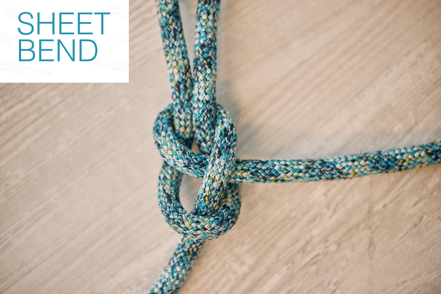 Buy stock photo Hiking rope in a knot against a wooden floor background in a studio from above. Strong sheet bend tie, cable or cord equipment to secure safety while mountain climbing or extreme sports for athletes.