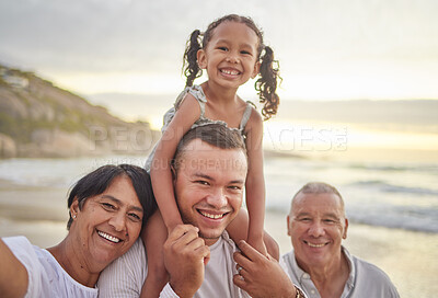Buy stock photo Happy mixed race family of four walking on the beach. A cute girl enjoying the sand and sea with their dad, grandfather and grandmother. Grandparents with their granddaughter and son outdoors