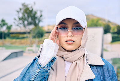Buy stock photo Portrait, fashion or sunglasses with an islamic woman outdoor in a cap and scarf for contemporary style. Muslim, faith or hijab with a trendy young arab female person posing outside in modern eyewear