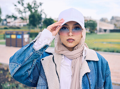 Buy stock photo Portrait, fashion or eyewear with a muslim woman outdoor in a cap and scarf for contemporary style. Islam, faith and hijab with a trendy young arab female person posing outside in modern sunglasses