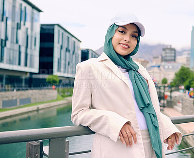 Buy stock photo Portrait, fashion or religion with a happy muslim woman in th city wearing a cap and scarf for urban style. Islam, faith or hijab with a trendy young arab person smiling outside in modern clothes