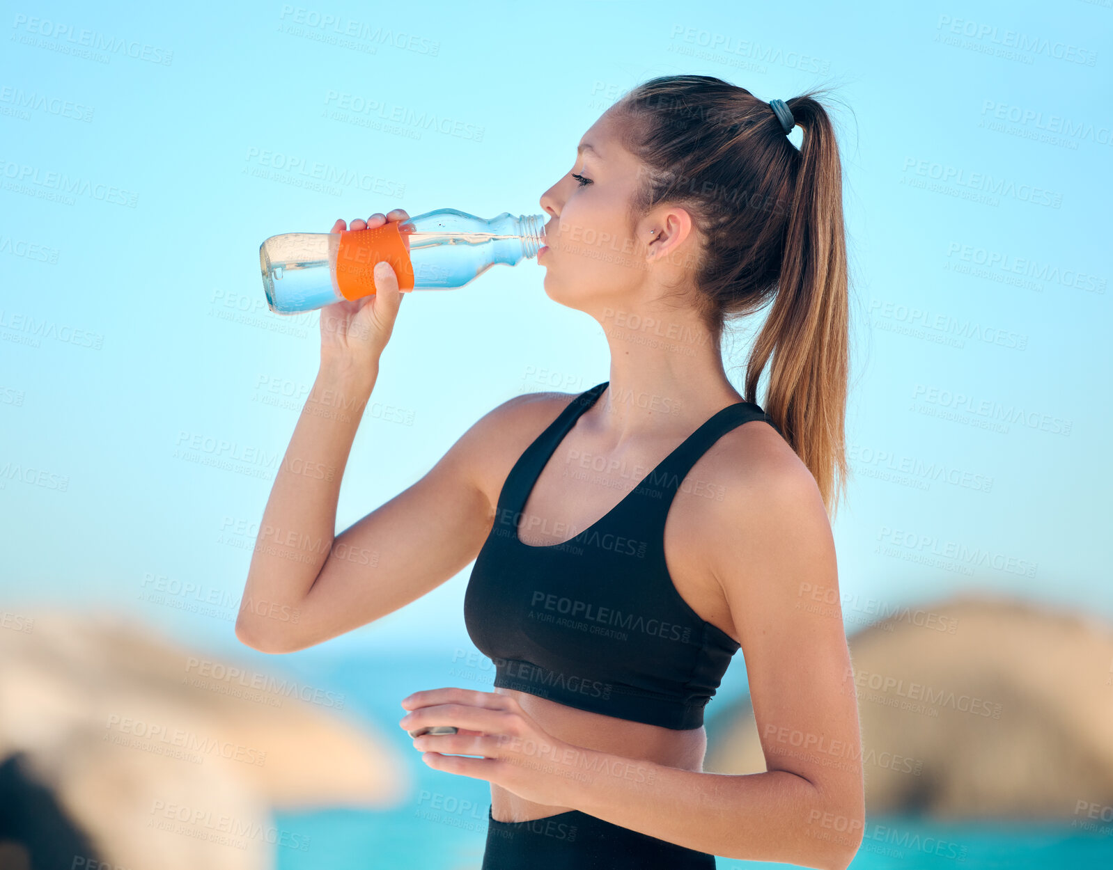 Buy stock photo Woman, athlete and drinking water at the beach for fitness, exercise or training at the sea. Girl, person and drink from bottle in outdoor workout, yoga and calm break or rest in summer exercising